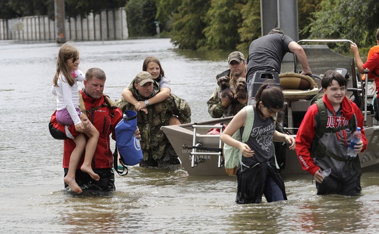 Residents are rescued from their homes surrounded by floodwaters from Tropical Storm Harvey on Sunday, Aug. 27, 2017, in Houston, Texas. (AP Photo/David J. Phillip)