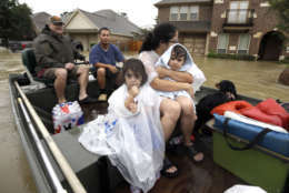 A family is evacuated from their home as floodwaters from Tropical Storm Harvey rise Monday, Aug. 28, 2017, in Spring, Texas. (AP Photo/David J. Phillip)