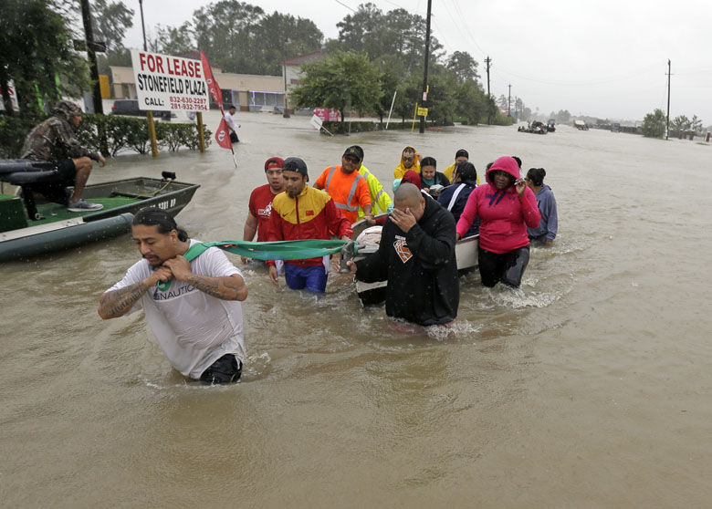 Evacuees wade down Tidwell Road as floodwaters from Tropical Storm Harvey rise Monday, Aug. 28, 2017, in Houston. (AP Photo/David J. Phillip)