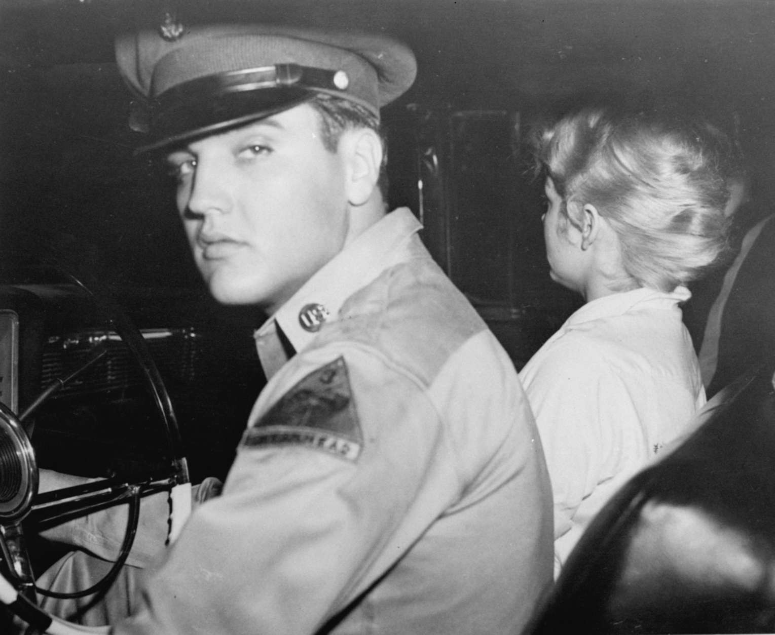 Pvt. Elvis Presley, accompanied by his girlfriend Anita Wood, prepared to drive from his home in Killeen, Texas to join his Army outfit at Ft. Hood, Texas late Friday night, September 21, 1958.  The rock 'n roll singer is being transferred to Germany.  Anita, who had been crying, refused to face the camera because she said she was red-eyed. (AP Photo)