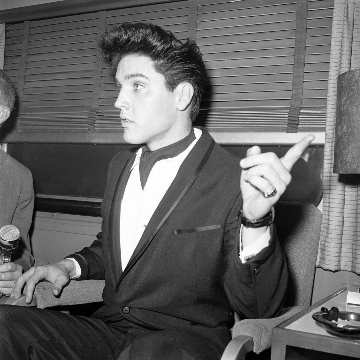 Singer Elvis Presley gestures during a press conference inside his private railroad car at Los Angeles Union Station, California, United States as he arrived on April 20, 1960 to make a movie. (AP Photo/HPM)