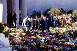 Pallbearers carry the flower covered coffin of Elvis Presley into the Forest Hills Cemeteries mausoleum in Memphis, Aug. 18, 1977. Flowers covered the area around the mausoleum and were later handed out to mourners. (AP Photo)
