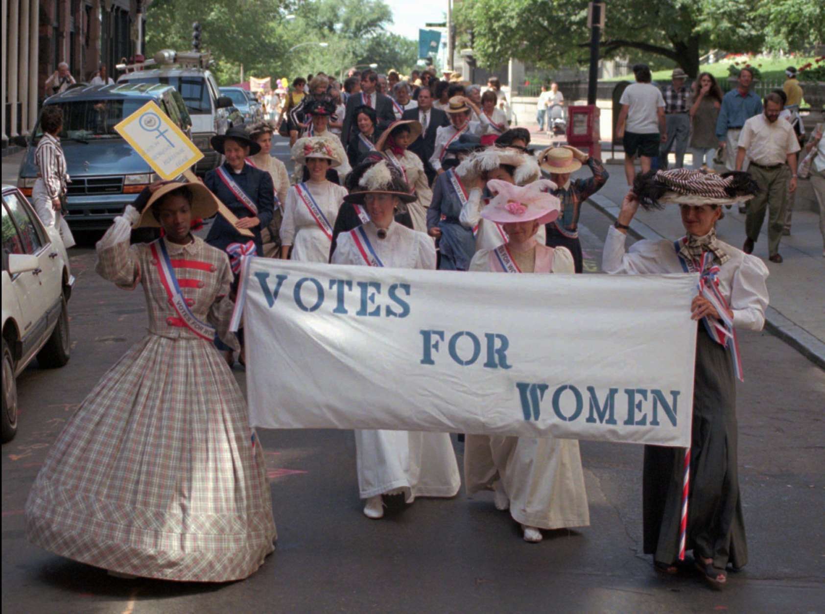 A parade to commemorate the 75th anniversary of women's suffrage proceeds down Beacon St. enroute from the Statehouse to Faneuil Hall in Boston Friday, August 25, 1995. Leading the parade, from left, are Chanel Lewis of New Orleans, Helen Hannon of Somerville, Mass., Judi Wright of Boston, and Linda McLaughlin of Marblehead, Mass. (AP Photo/Julia Malakie)