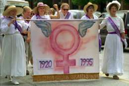 A group calling themselves the Goddesses of the Universalist Church from Woodstock, Vt., carry a banner celebrating 75 years of women's suffrage during a parade in Montpelier, Vt., Saturday, August 26, 1995.  More than 300 gathered to march and listen to speakers celebrating the passage of the 19th amendment to the U.S. Constitution, which gave women the right to vote. (AP Photo/Craig Line)