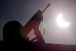 A French soldier, part of NATO's peacekeeping forces in Kosovo, stands guard beneath the solar eclipse on the ethnic Albanian side of the bridge dividing Kosovska Mitrovica, about 30 kilometers (20 miles) north of Pristina, Yugoslavia, Wednesday August 11, 1999. (AP Photo/Amel Emric)