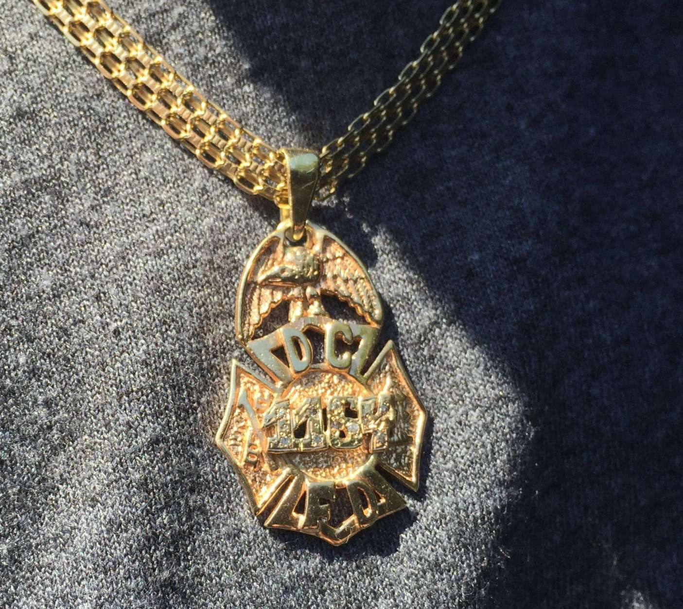 "This is like the second family," former D.C. fire chief Donald Edwards said at Wednesday’s fundraiser for Dane Smothers Jr. This pendant belongs to 21-year D.C. Fire Department veteran Adrian "Stokey" Stokes, who rode his motorcycle to the fundraiser at Tune Inn. "The motorcycle community always supports charities. We always give back," Stokes said. "But this time, it's special for us, because this time, it’s one of our own." (WTOP/Kristi King)