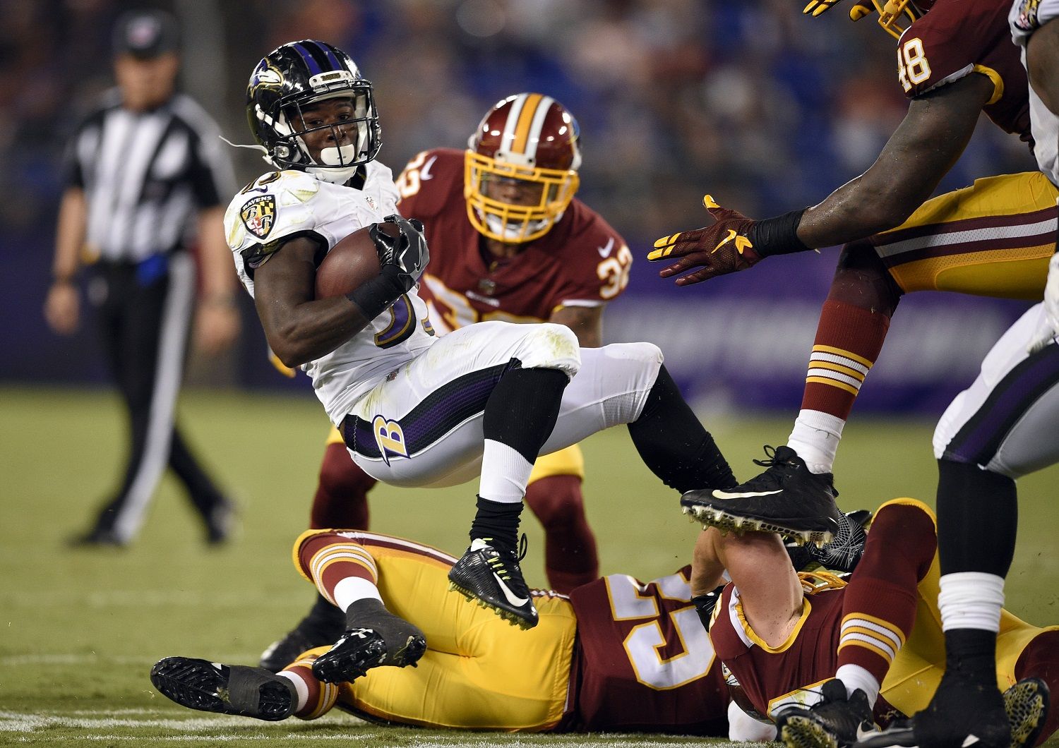 Baltimore Ravens running back Taquan Mizzell (33) is tackled in the second half of a preseason NFL football game against the Washington Redskins, Thursday, Aug. 10, 2017, in Baltimore. (AP Photo/Nick Wass)