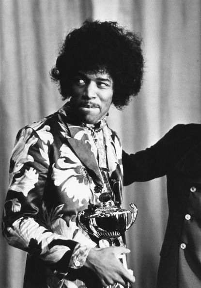 1st October 1967:  Influential rock guitarist, singer and songwriter Jimi Hendrix  (1942 - 1970) holds an award which he has just received from Radio One DJ Jimmy Savile.  (Photo by Express/Express/Getty Images)