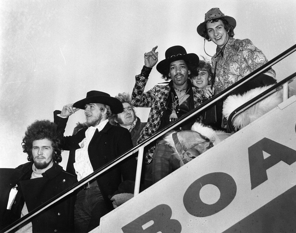 1968:  Jimi Hendrix and Mitch Mitchell of The Jimi Hendrix Experience wave goodbye as they board an aeroplane at London Airport, with assorted members of the Byrds, the Soft Machine and the Alan Price Set.  (Photo by J. Wilds/Keystone/Getty Images)