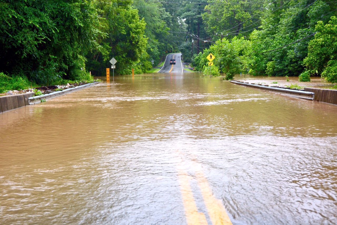 Swift water rushes over Woodburn Road in Annandale, Virginia, on Friday, Aug. 4. Heavy rains triggered flash flooding throughout the D.C. area. (WTOP/Dave Dildine)