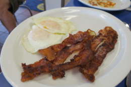 Photo shows a plate of bacon and eggs