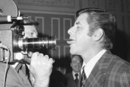 Comedian Jerry Lewis, right, hams it up as he sticks out his tongue at a television camera during reception in his honor at a New York Hotel, Monday, June 7, 1976, New York. Lewis will make his legitimate theater debut on Broadway next season, starring in a new production of Hellzapoppin. (AP Photo/Ron Frehm)