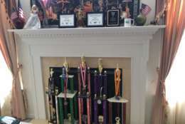 A host of awards line the fireplace at Gorti's home from the tournaments she's won. (WTOP/Noah Frank)