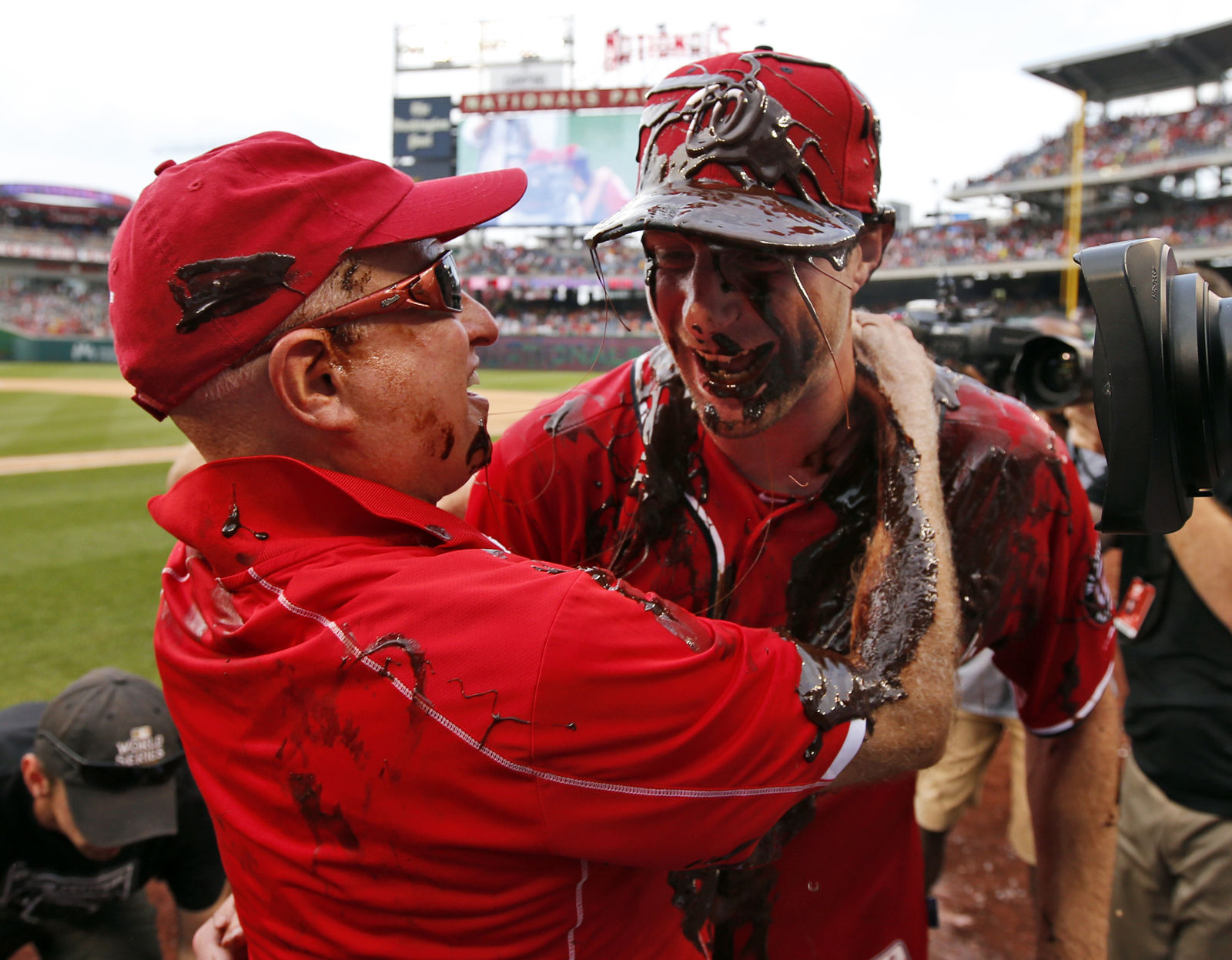 Washington Nationals owner Mark Lerner, left, embraces Washington Nationals starting pitcher Max Scherzer, who is covered with chocolate syrup, after Scherzer's no-hitter baseball game against the Pittsburgh Pirates at Nationals Park, Saturday, June 20, 2015, in Washington. The Nationals won 6-0. (AP Photo/Alex Brandon)