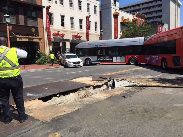 Scene of a bus crash into a building on the 600 block of H Street NW. Metro said the steel plates were responsible for the accident. (WTOP/James Hoeflinger)