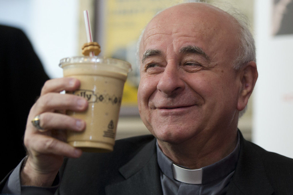 Archbishop Vincenzo Paglia lifts a milkshake during a news conference to pick an official milkshake for the upcoming World Meeting of Families, Monday, March 9, 2015, at a Potbelly Sandwich Shop in Philadelphia. Paglia met with about a dozen students at the shop in downtown Philadelphia to pick the milkshake that would benefit planning efforts for Septembers event. Paglia, the president of the council in charge of the event, settled on the flavor #PopeInPhilly.  Pope Francis will attend the closing event Sept. 26 of the world meeting. The next day hell celebrate an outdoor Mass.  Fifty cents from every shake sold at three locations will benefit planning for the events.  (AP Photo/Matt Rourke)
