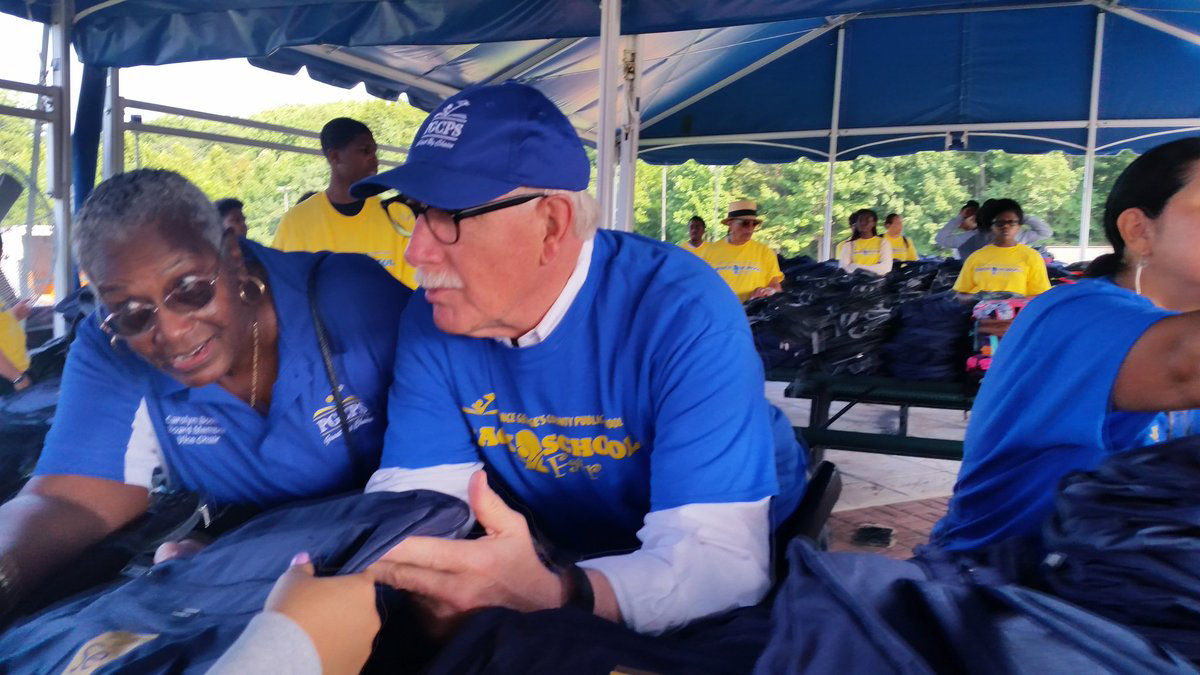 Prince George's County Public Schools CEO Dr. Kevin Maxwell hadning out backpacks at the Back-to-School fair in Bowie, Maryland. (WTOP/Kathy Stewart)