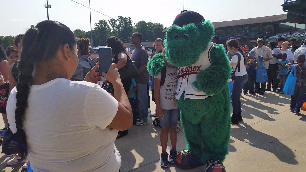 Louie, the mascot for the Bowie Baysox, poses with a fan at the Back-to-School Fair at Prince George's Stadium. (WTOP/Kathy Stewart)