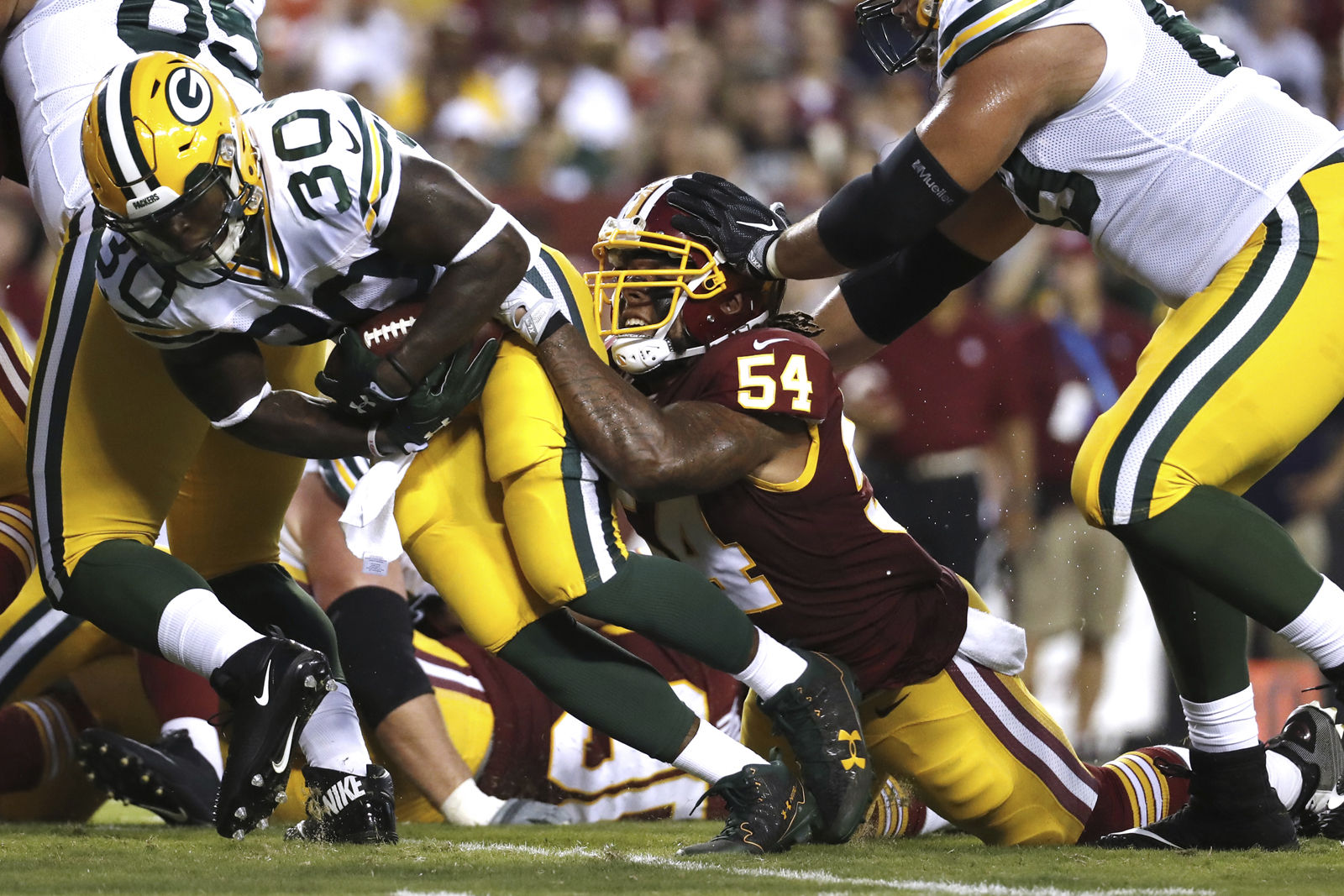 Green Bay Packers running back Jamaal Williams (30) is stopped by Washington Redskins inside linebacker Mason Foster (54) during the first half of an NFL preseason football game in Landover, Md., Saturday, Aug. 19, 2017. (AP Photo/Alex Brandon)