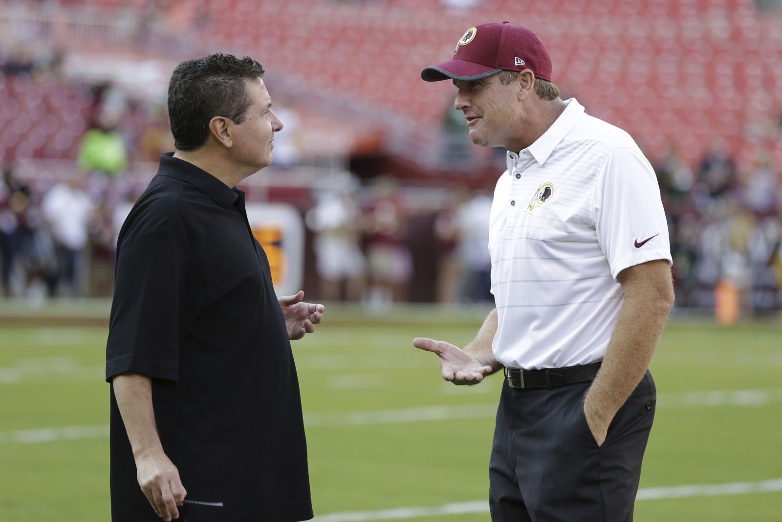 Washington Redskins owner Dan Snyder talks with head coach Jay Gruden, right, before an NFL pre-season football game against the Green Bay Packers in Landover, Md., Saturday, Aug. 19, 2017. (AP Photo/Mark Tenally)