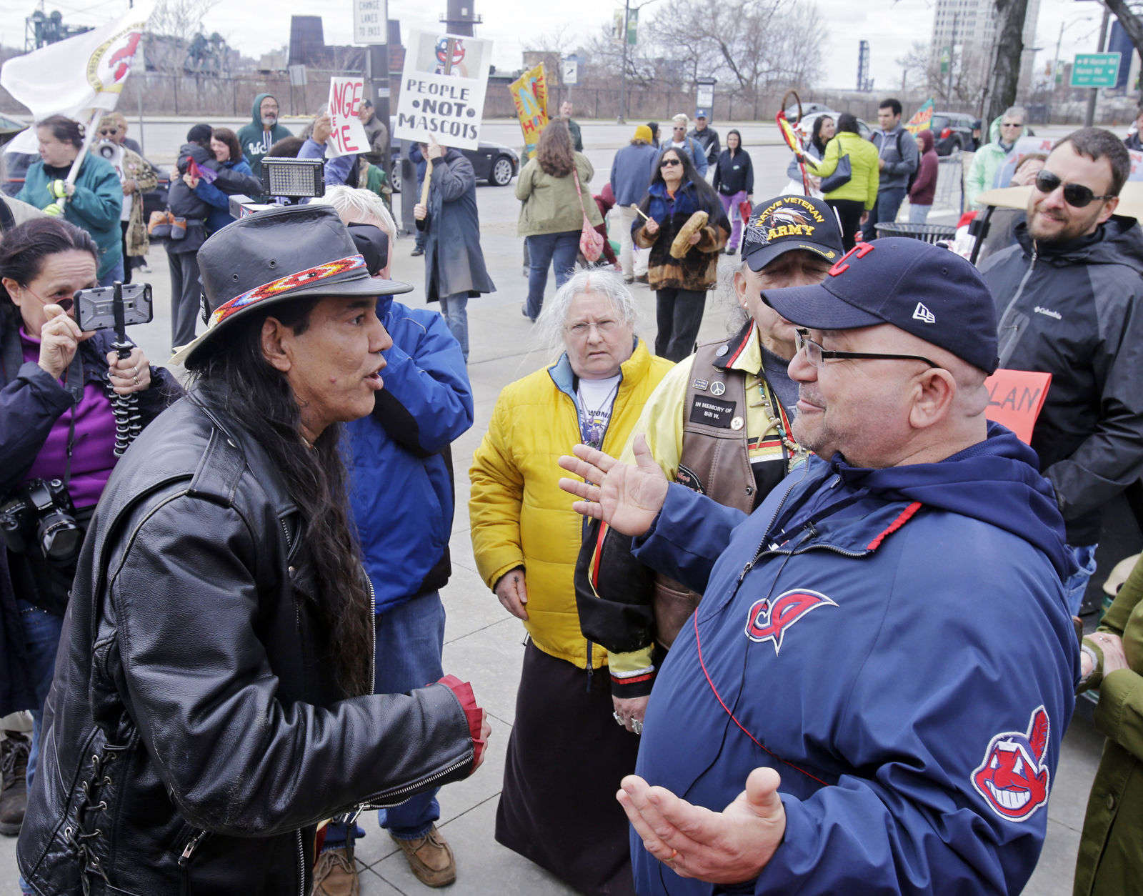 In April 2017, MLB Commissioner Rob Manfred met with the owners of the Cleveland Indians to express his desire that they "transition away from the Chief Wahoo logo."
FILE - In this April 10, 2015, file photo, Philip Yenyo, left, executive director of the American Indians Movement for Ohio, talks with a Cleveland Indians fan before a baseball game against the Detroit Tigers, in Cleveland.  (AP Photo/Mark Duncan, File)