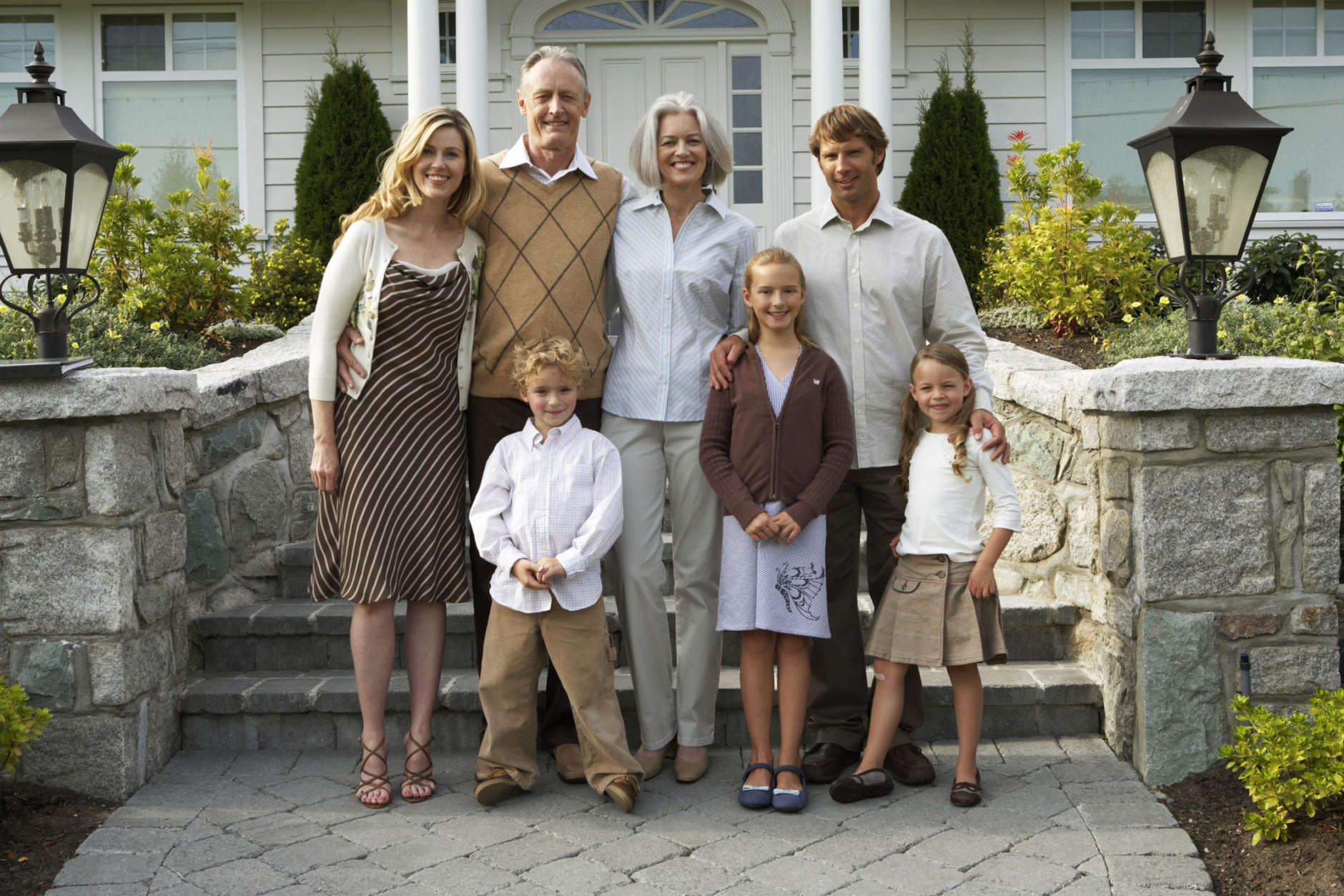 Three children (5-12 years) standing with parents and grandparents, portrait