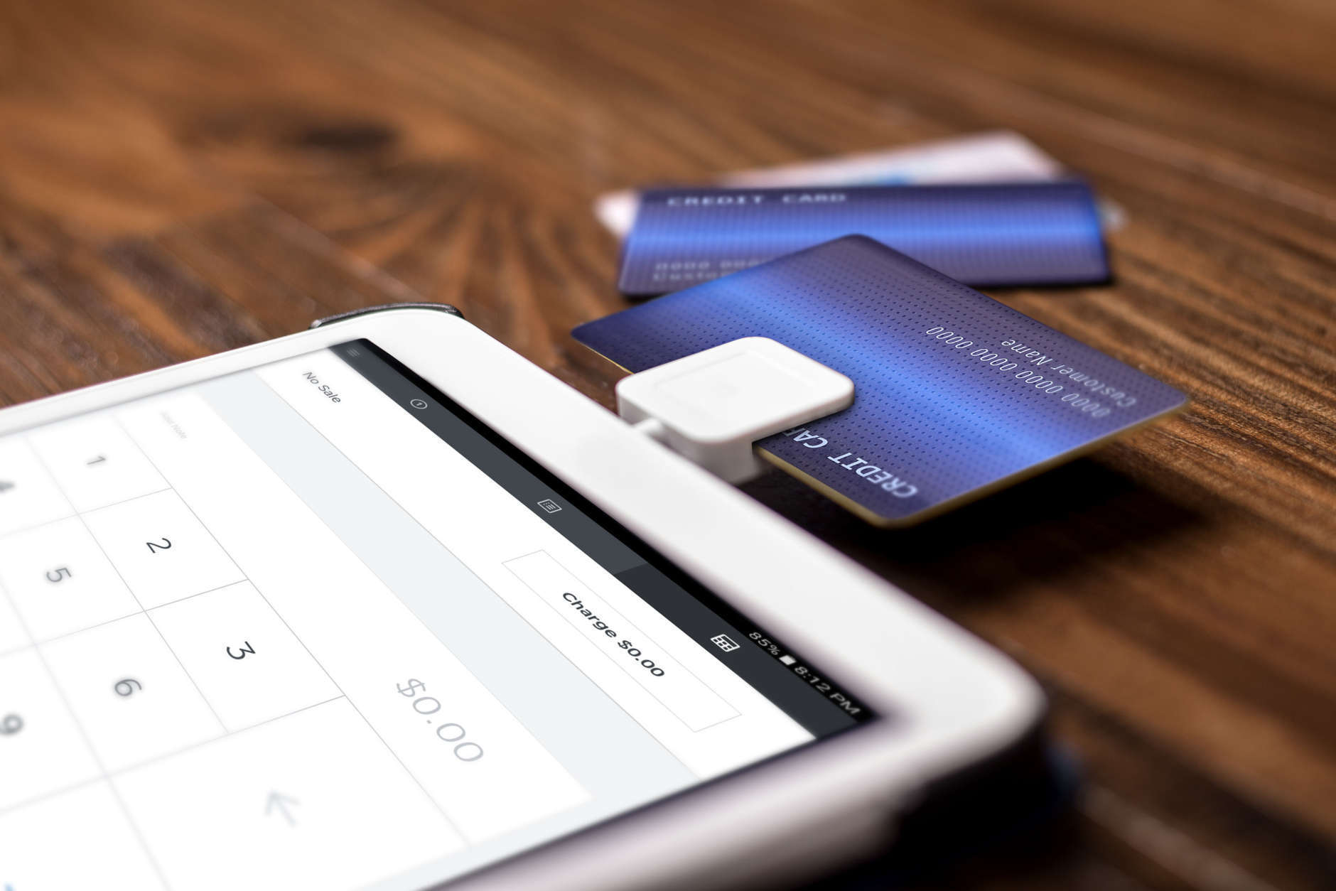 Credit card payment on a swipe or chip reader app on a tablet used by small or online businesses.  The electronic device is used as a modern cash register or for banking.  The image depics modern method of currency transactions for business.