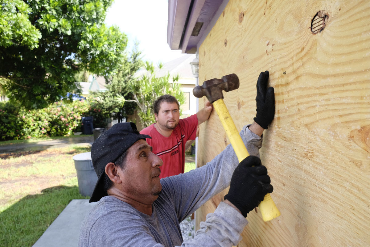 Pedro Reimundo installs wood shutters on a home in Florida City, Fla., Friday, Sept. 8, 2017. Hurricane Irma weakened slightly Friday but remained a dangerous and deadly hurricane taking direct aim at Florida, threatening to march along the peninsula's spine and deliver a blow the state hasn't seen in more than a decade. (AP Photo/Gaston De Cardenas)