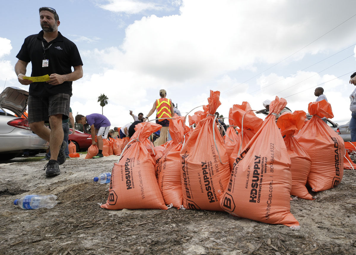 Sandbags ready for distribution are stacked in a parking lot as residents arrive to pick them up in preparation for Hurricane Irma, Friday, Sept. 8, 2017, in Orlando, Fla. (AP Photo/John Raoux)