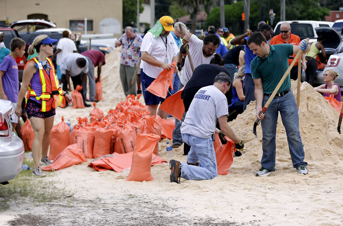 Orlando city employees and volunteers fill sandbags for residents as they prepare for Hurricane Irma, Friday, Sept. 8, 2017, in Orlando, Fla. Lines of vehicles stretched for miles and many waited several hours to get the sandbags. (AP Photo/John Raoux)