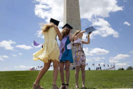 George Washington University graduates Serena Williams, left, and Hannah Raymond, center and Katie Kenny, right, struggle against a strong wind as they pose for graduations pictures near the Washington Monument, Sunday, May 15, 2016, in Washington, after their commencement ceremony on the National Mall. (AP Photo/Carolyn Kaster)