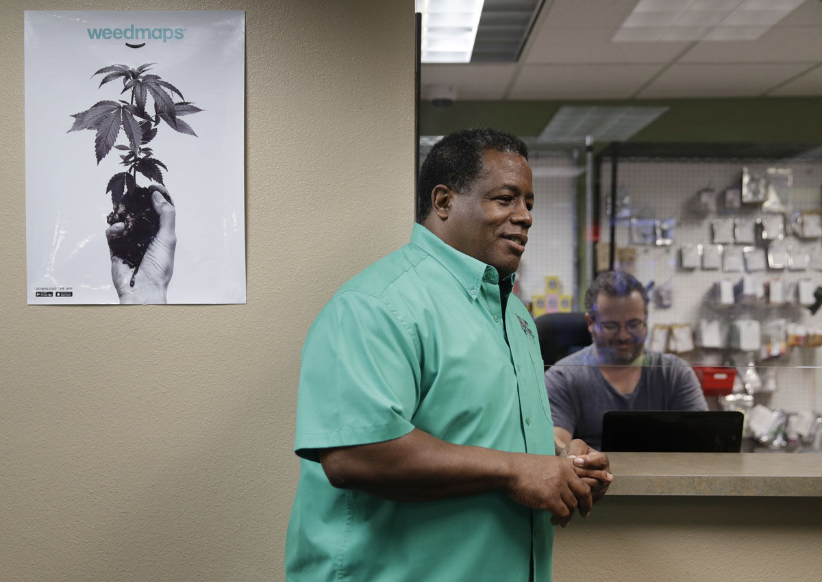 In this Sept. 8, 2017, photo, Frank Hawkins speaks with employees at the Nevada Wellness Center marijuana dispensary in Las Vegas. The former running back for the Raiders has two things that set him apart from most football players, a Super Bowl ring and a thriving pot shop just off the glittering Las Vegas Strip. (AP Photo/John Locher)