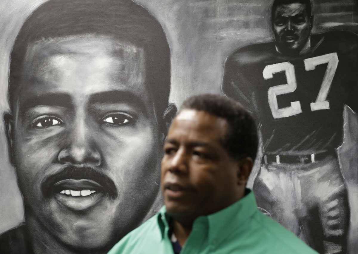 In this Sept. 8, 2017, photo, Frank Hawkins stands in front of a painting of himself at the Nevada Wellness Center marijuana dispensary in Las Vegas. The former running back for the Raiders has two things that set him apart from most football players, a Super Bowl ring and a thriving pot shop just off the glittering Las Vegas Strip. (AP Photo/John Locher)