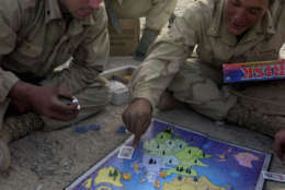 Marines from Bravo Company, 1st LAR, BLT 1/1 play a game of RISK during some downtime at the Marine's base at Kandahar International Airport in Afghanistan, Wednesday, Jan. 2, 2002. From right are, Lance Cpl., Nick Bronte from Pleasanton, Calif., who got the board game as a Christmas present from his mom, Cpl., Ryan Dixon, from Seattle, Wash., and Lance Cpl. Isaac Secondine, from Witchita, KS.  (AP Photo/Rob Curtis, Pool)