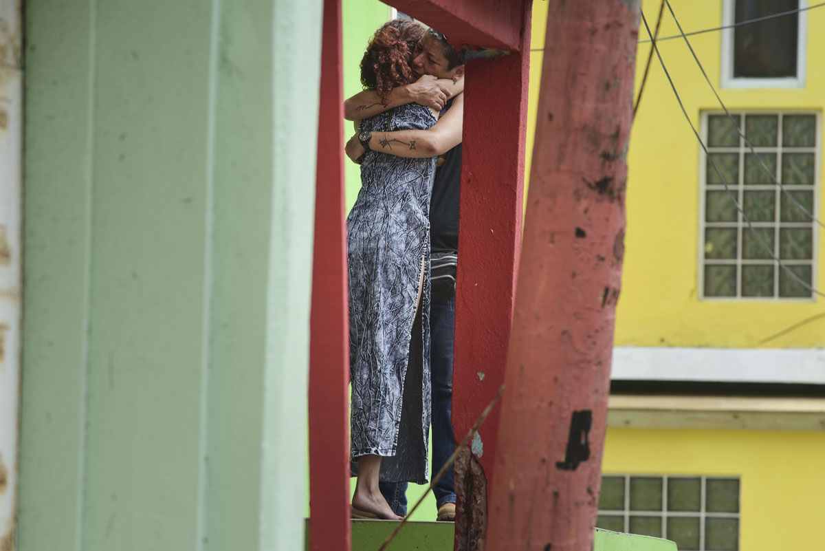 Residents at La Perla community in Old San Juan comfort one another as the community recovers from Hurricane Maria, in San Juan, Puerto Rico, Monday, Sept. 25, 2017. The island territory of more than 3 million U.S. citizens is reeling in the devastating wake of Hurricane Maria. (AP Photo/Carlos Giusti)