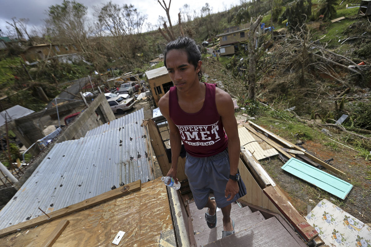 Jose Colon walks up the stairs of his friend's destroyed home, in the aftermath of Hurricane Maria, in Aibonito, Puerto Rico, Monday, Sept. 25, 2017. The U.S. ramped up its response Monday to the humanitarian crisis in Puerto Rico while the Trump administration sought to blunt criticism that its response to Hurricane Maria has fallen short of it efforts in Texas and Florida after the recent hurricanes there. (AP Photo/Gerald Herbert)