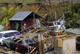 Jose Garcia Vicente, right, works with Jose Colon, as he starts to salvage his destroyed home, in the aftermath of Hurricane Maria, in Aibonito, Puerto Rico, Monday, Sept. 25, 2017. The U.S. ramped up its response Monday to the humanitarian crisis in Puerto Rico while the Trump administration sought to blunt criticism that its response to Hurricane Maria has fallen short of it efforts in Texas and Florida after the recent hurricanes there. (AP Photo/Gerald Herbert)