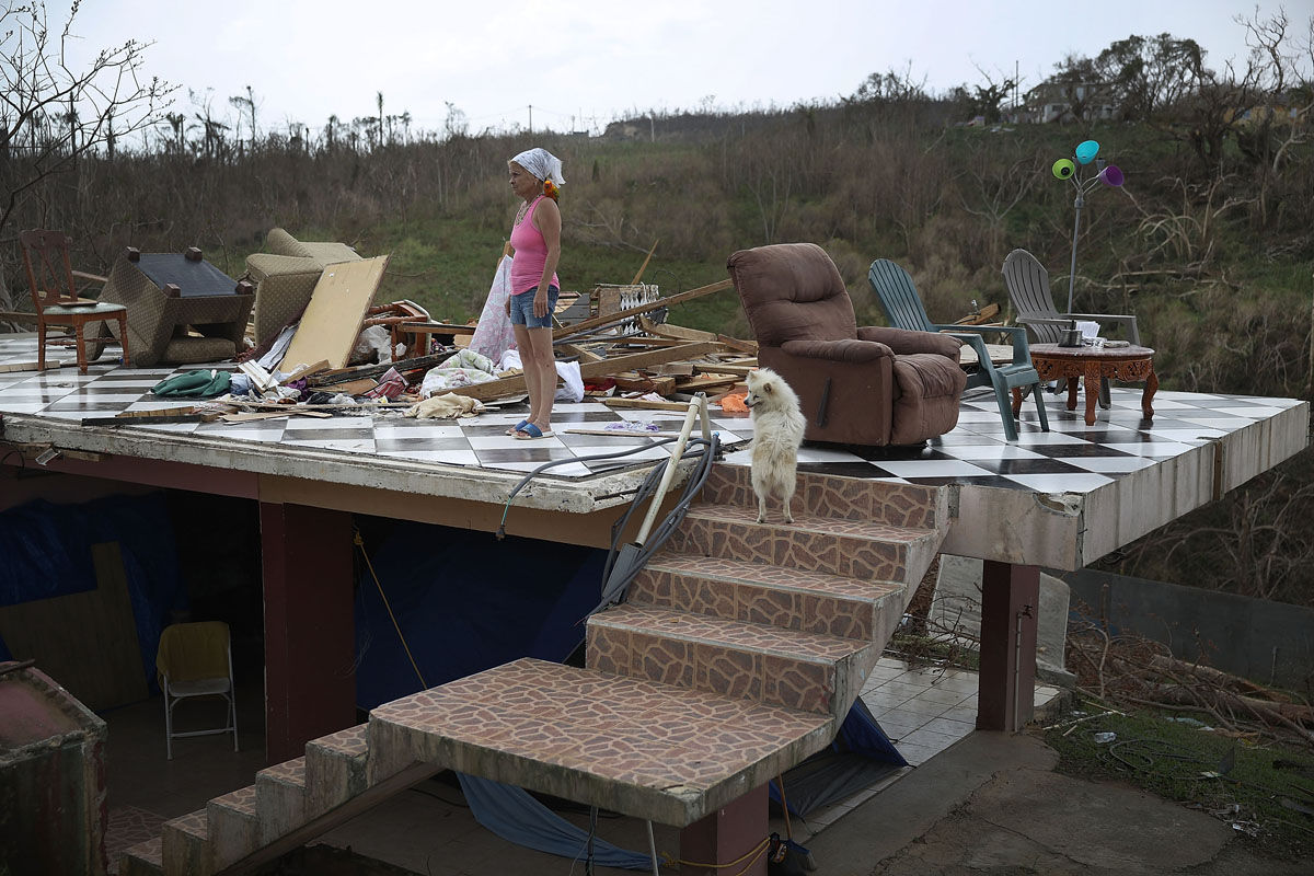 COROZAL, PUERTO RICO - SEPTEMBER 27:  Irma Maldanado stands with Sussury her parrot and her dog in what is left of her home that was destroyed when Hurricane Maria passed through on September 27, 2017 in Corozal, Puerto Rico.  Puerto Rico experienced widespread damage including most of the electrical, gas and water grid as well as agriculture after Hurricane Maria, a category 4 hurricane, passed through.  (Photo by Joe Raedle/Getty Images)