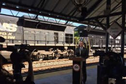 VRE CEO Doug Allen VRE pauses as a freight train rumbles by during his remarks at the first national Rail Safety Week. (WTOP/John Aaron)