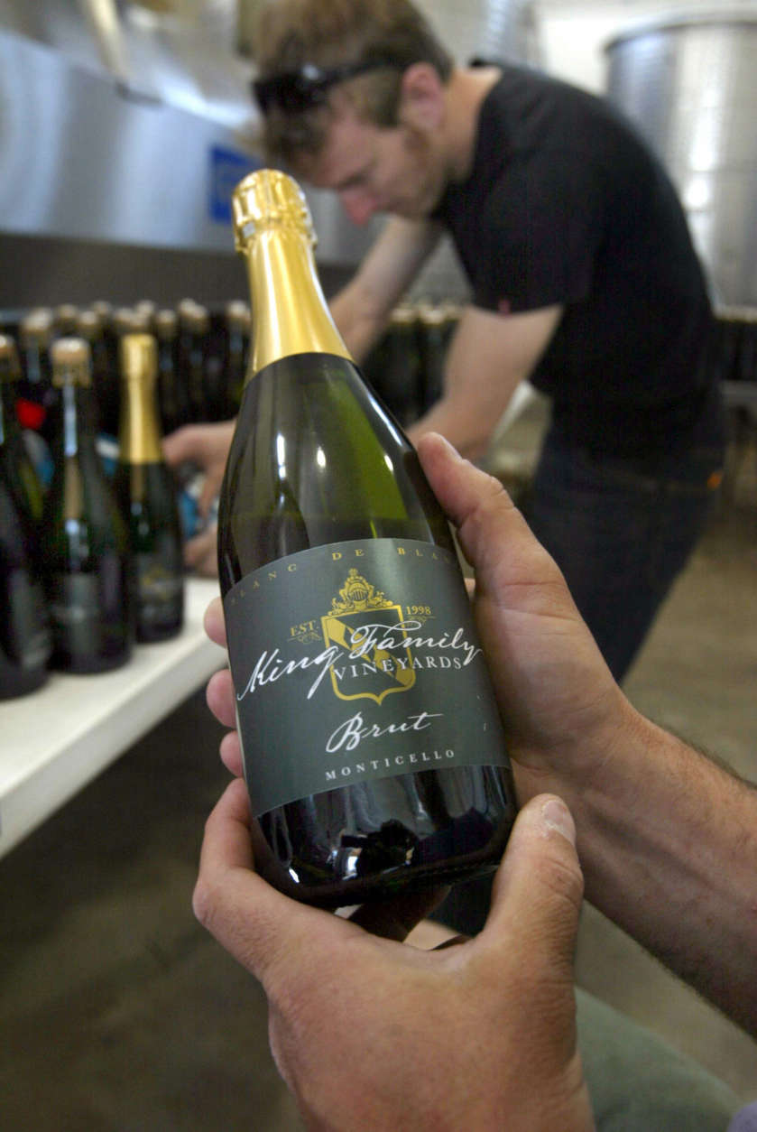 An employee hold a bottle of champagne at the King Family Vineyards on Wednesday, May 7, 2008, in Crozet, Va.  David King, not shown, is the owner of King Family Vineyards and board chairman of the state-run Virginia Wine Distribution Co. The nonprofit distribution company retains the three-tier system used by a majority of states following the repeal of Prohibition in 1933 that takes the wine from the winery to the wholesaler to the retailer.  (AP Photo/Lisa Billings)