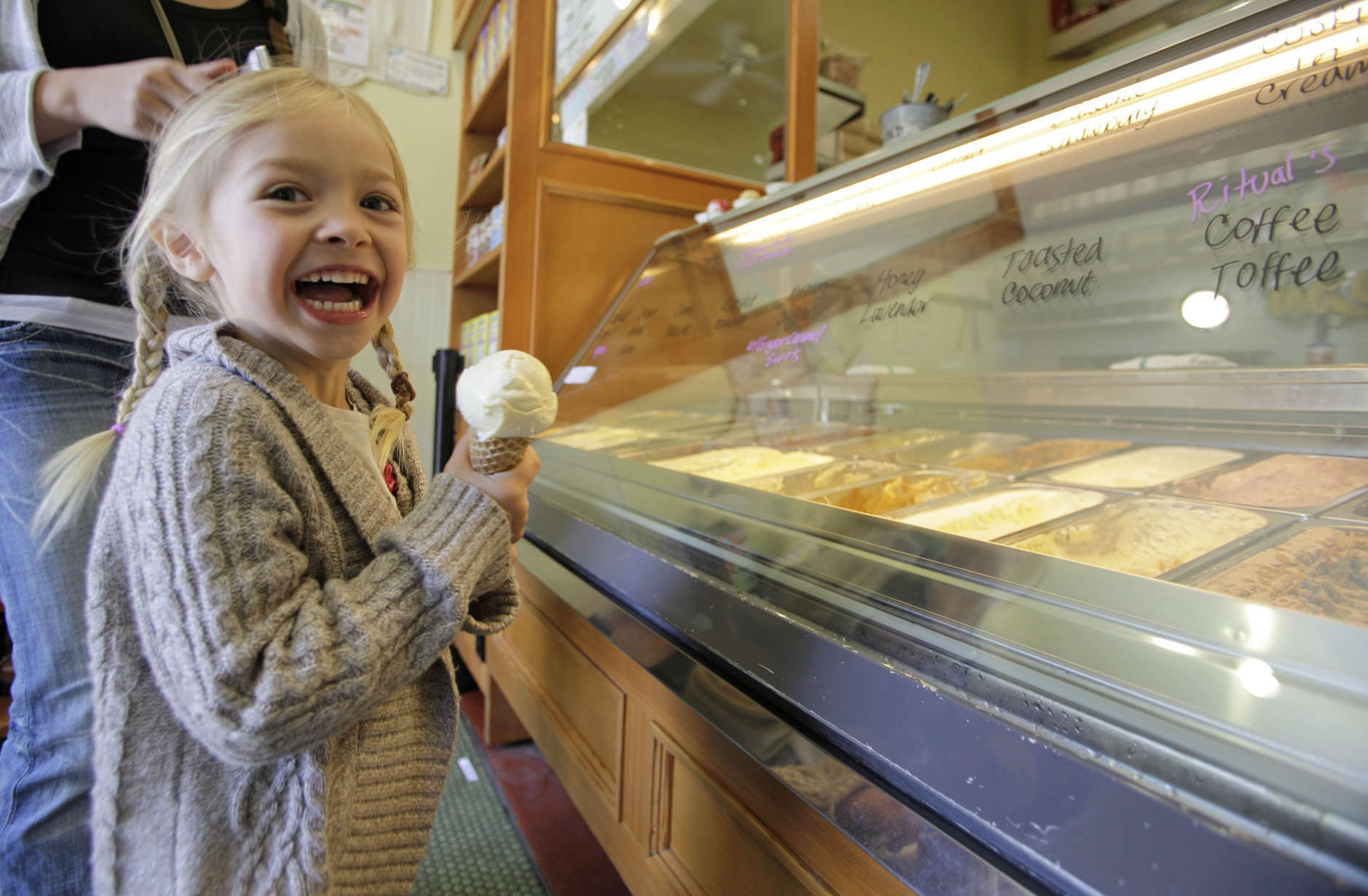 In this photo taken Wednesday June 1, 2011, Sophia Santos, 4, smiles after getting an ice cream cone at the Bi-Rite Creamery in San Francisco, Calif. At Bi-Rite Creamery, both their scooped and soft serve ice cream offerings are made from Straus Family Organic Dairy products.    (AP Photo/Eric Risberg)