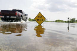 A truck passes down a road with rising water, Friday, Sept. 1, 2017, in Sargent, Texas. Water from Hurricane Harvey is causing rivers in the area to rise. (AP Photo/Eric Gay)
