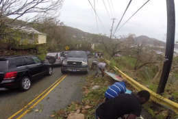 In this image made from video, motorists remove debris caused by Hurricane Irma from the road in St. Thomas, U.S. Virgin Islands, Thursday, Sept. 7, 2017. Hurricane Irma weakened slightly Thursday with sustained winds of 175 mph, according to the National Hurricane Center. The storm boasted 185 mph winds for a more than 24-hour period, making it the strongest storm ever recorded in the Atlantic Ocean. The storm was expected to arrive in Cuba by Friday. It could hit the Florida mainland by late Saturday, according to hurricane center models. (AP Photo/Ian Brown)