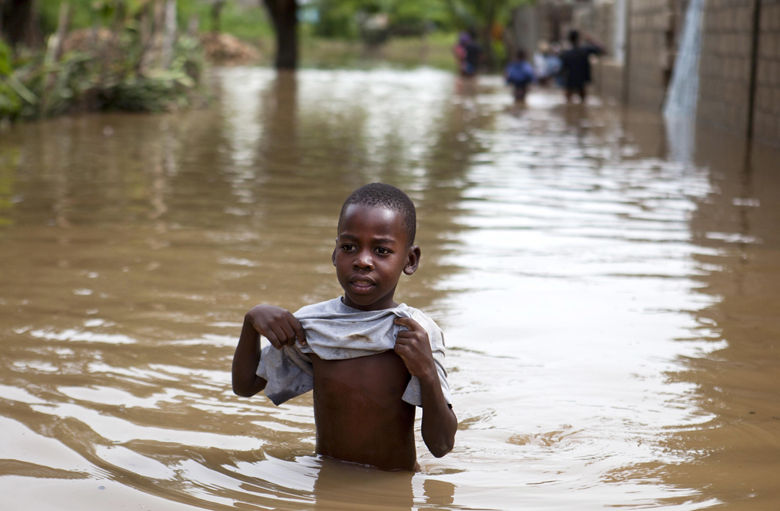 A boy walks in the floodwaters of Hurricane Irma, in Fort-Liberte, Haiti, Friday Sept. 8, 2017. Irma rolled past the Dominican Republic and Haiti and battered the Turks and Caicos Islands early Friday with waves as high as 20 feet (6 meters). ( AP Photo/Dieu Nalio Chery)