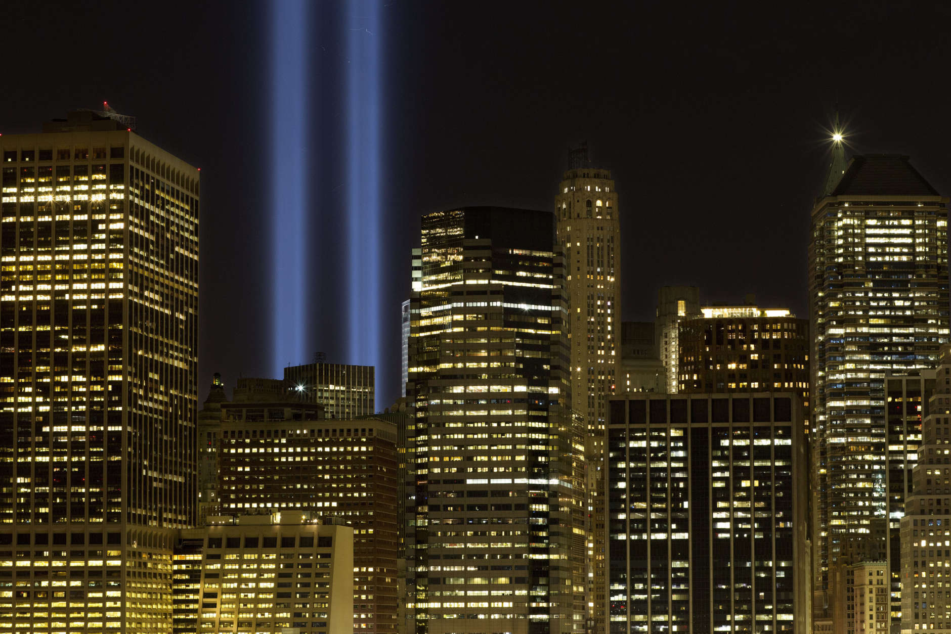 The Tribute in Light rises above the lower Manhattan skyline, Sunday, Sept. 10, 2017, in New York. The two blue pillars of light provide a visual reminder of how the Twin Towers, destroyed in the terrorist attacks of Sept. 11, 2001, once stood above the city skyline. (AP Photo/Mark Lennihan)