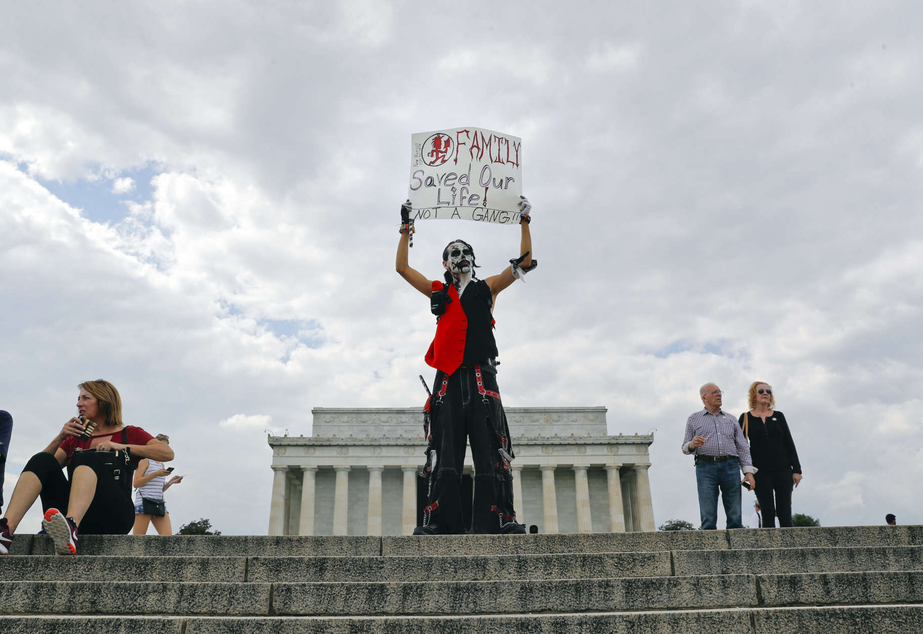 Fonz Tobin, 25, from Albuquerque, N.M., holds up a sign in front of the Lincoln Memorial in Washington, as he joins other supporters of the rap group Insane Clown Posse, during a rally, Saturday, Sept. 16, 2017, to protest and demand that the FBI rescind its classification of the juggalos as "loosely organized hybrid gang."(AP Photo/Pablo Martinez Monsivais)