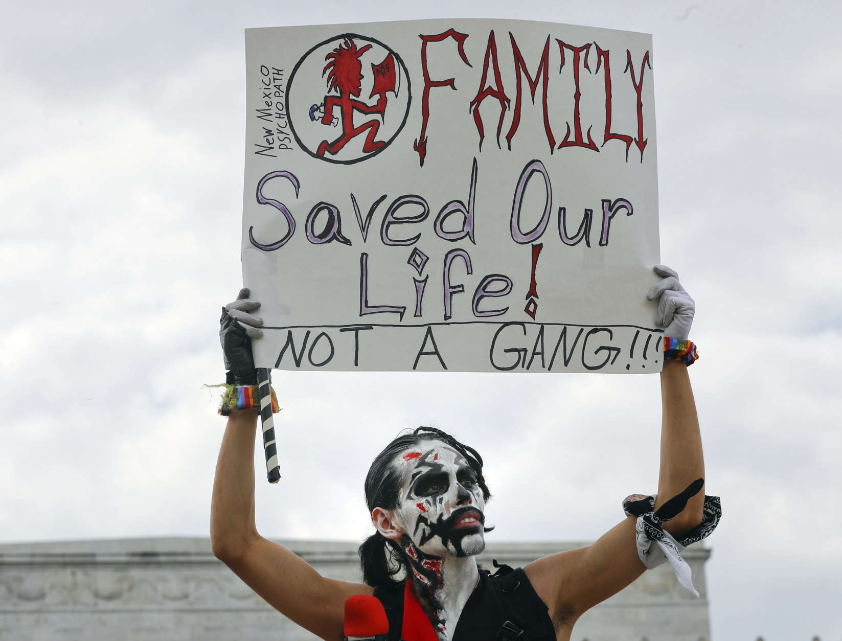 Fonz Tobin, 25, from Albuquerque, N.M., holds up a sign in front of the Lincoln Memorial in Washington, as he joins other supporters of the rap group Insane Clown Posse, during a rally Saturday, Sept. 16, 2017, to protest and demand that the FBI rescind its classification of the juggalos as "loosely organized hybrid gang."(AP Photo/Pablo Martinez Monsivais)
