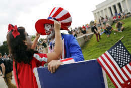 Theresa Lindsey, left, dressed as Snow White helps Timothy Schlarmann, center, dressed as Uncle Sam, who are from southern California, with his costume as they join other juggalos, as supporters of the rap group Insane Clown Posse are known, in front of the Lincoln Memorial in Washington during a rally, Saturday, Sept. 16, 2017, to protest and demand that the FBI rescind its classification of the juggalos as "loosely organized hybrid gang." (AP Photo/Pablo Martinez Monsivais)