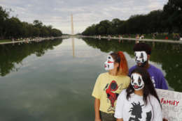 From left, sisters Melina, 17, and Tiffany Baker, 12, and Jajuan Dunkins, 17, join other juggalos, as supporters of the rap group Insane Clown Posse are known, in front of the Reflecting Pool along the National Mall in Washington during a rally, Saturday, Sept. 16, 2017. The event was to demand that the FBI rescind its classification of the juggalos as "loosely organized hybrid gang." (AP Photo/Pablo Martinez Monsivais)