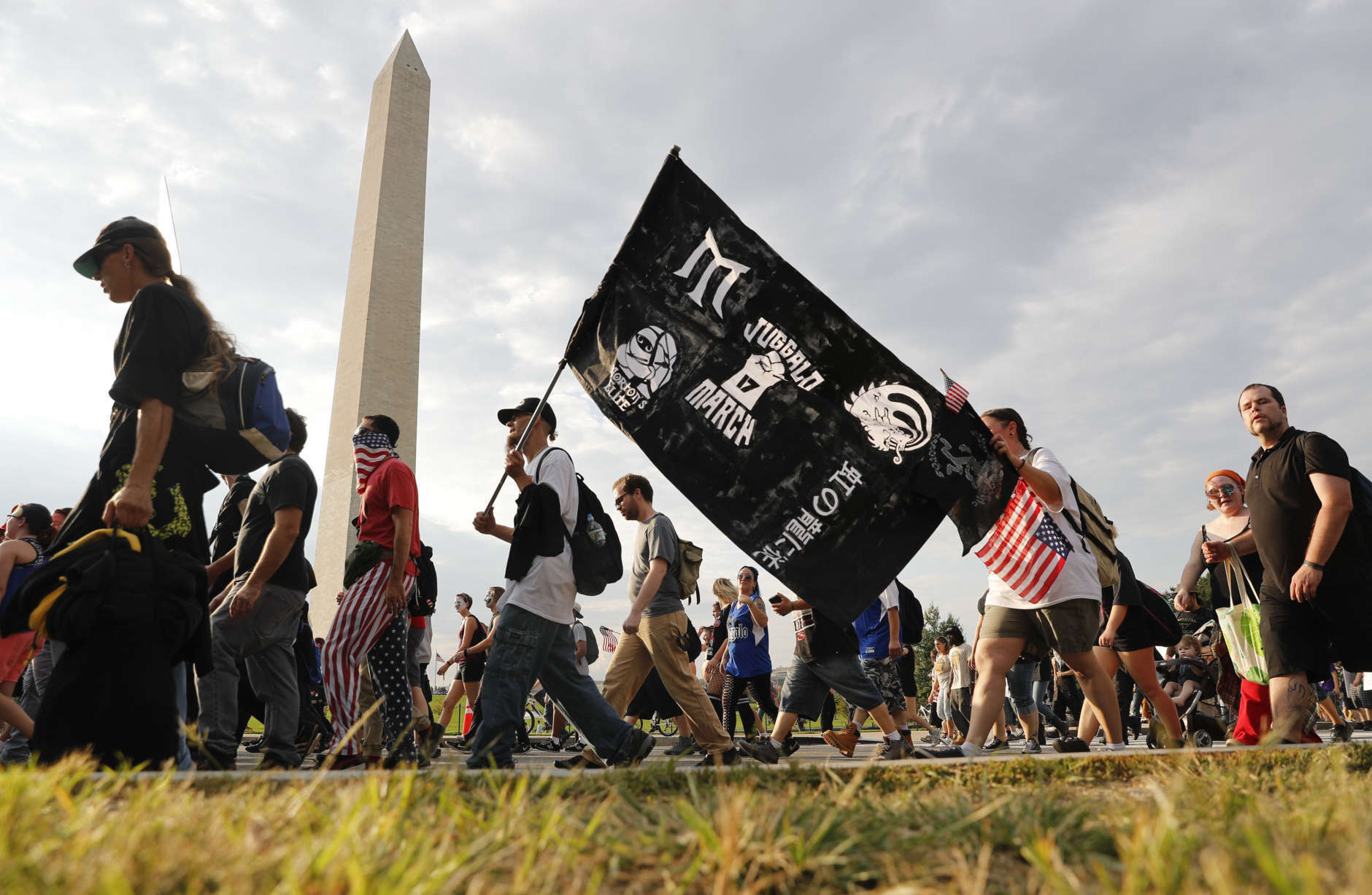 Juggalos, as supporters of the rap group Insane Clown Posse are known, march past the Washington Monument as they head towards the Lincoln Memorial in Washington during a rally, Saturday, Sept. 16, 2017. The event was held to demand that the FBI rescind its classification of the juggalos as a "loosely organized hybrid gang." (AP Photo/Pablo Martinez Monsivais)